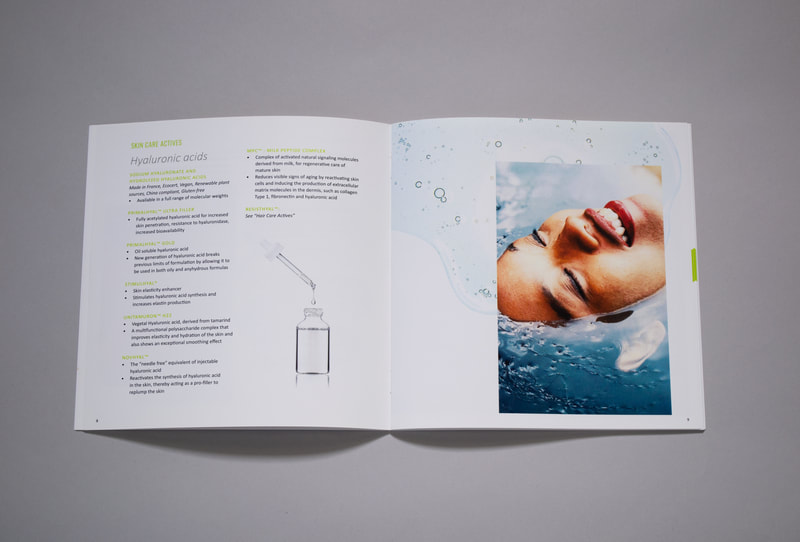A photograph of an inside spread of a brochure which features hyaluronic acid ingredients and an image of a woman who is smiling and partially submerged in water. The photograph is overlaid to a photo of a pale blue puddle of a skin care serum. 