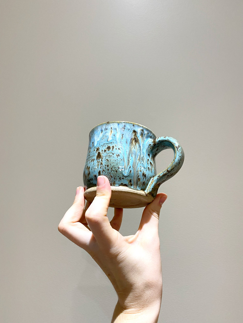 Turquoise speckled mug with melting texture.